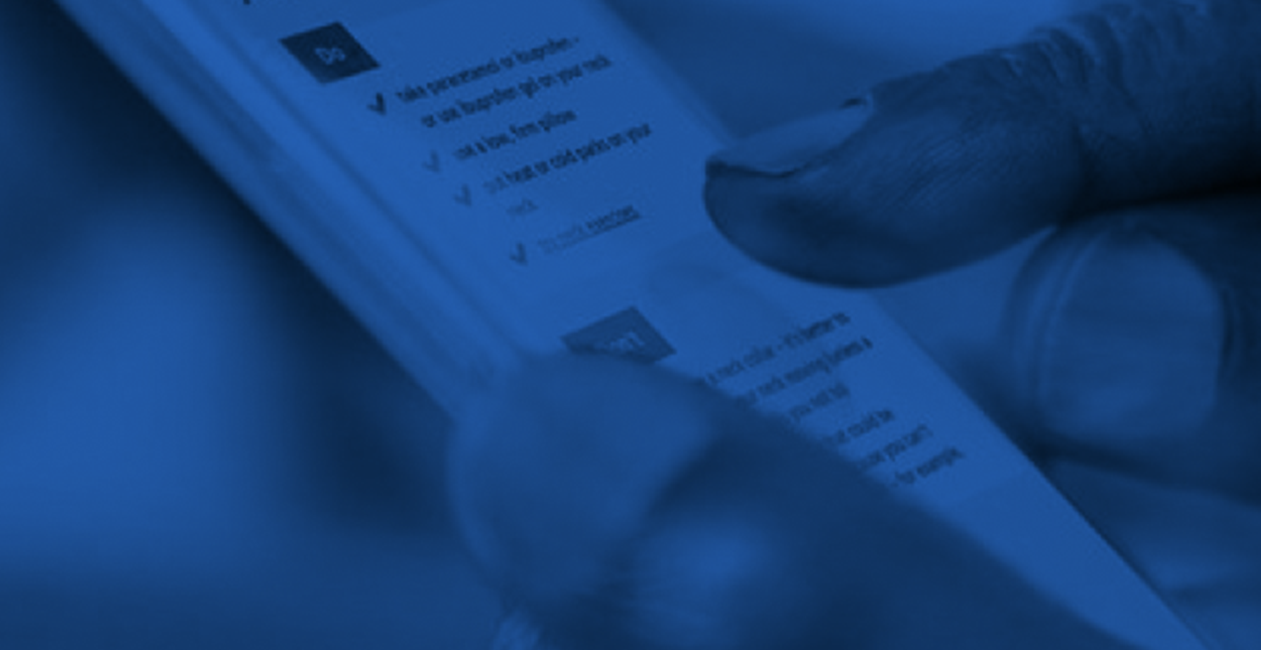 Close-up of thumb and forefinger of someone viewing an NHS page on mobile. In shades of dark blue and black.
